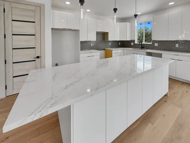 a large kitchen with stainless steel appliances kitchen island a large counter top and a sink