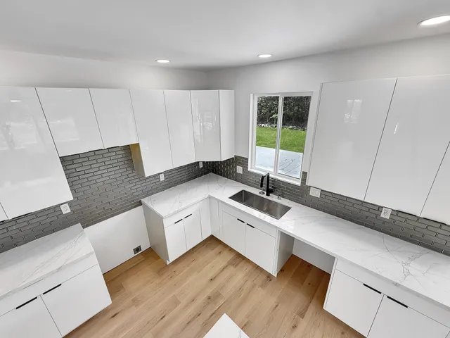 a living room with stainless steel appliances kitchen island granite countertop furniture and a wooden floor