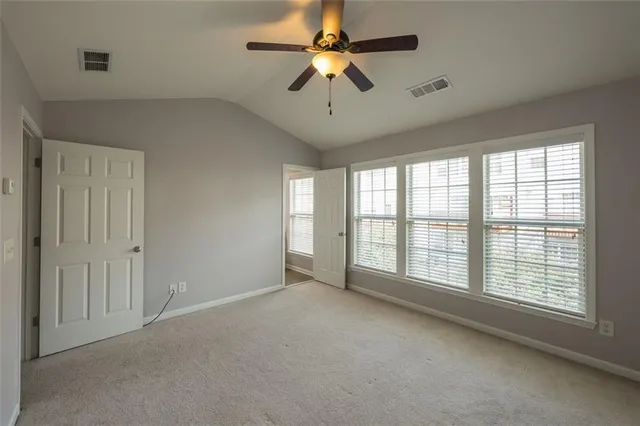 an empty room with closet and a ceiling fan