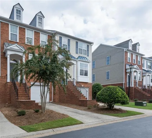 a front view of a house with yard and parking