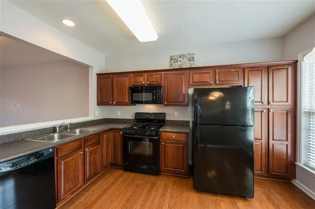 a kitchen with a refrigerator stove and wooden cabinets