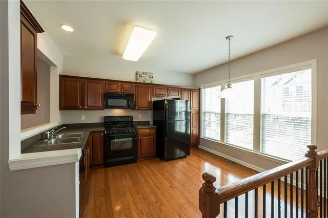 a kitchen with stainless steel appliances granite countertop a refrigerator stove top oven and sink