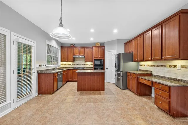 a kitchen with stainless steel appliances granite countertop a stove sink and cabinets