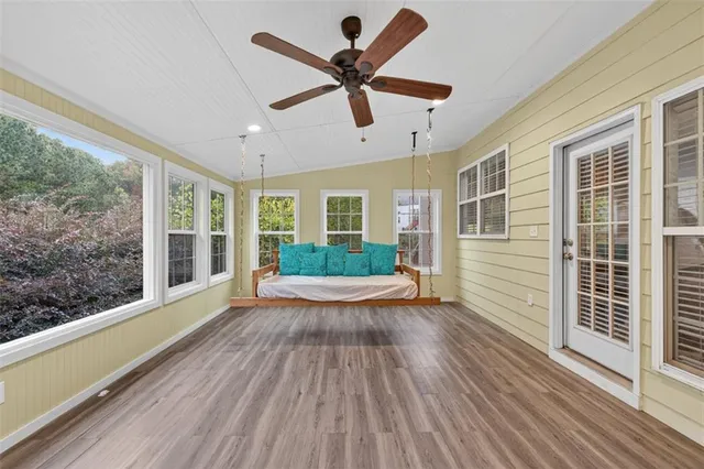 a view of an empty room with wooden floor fireplace and a window