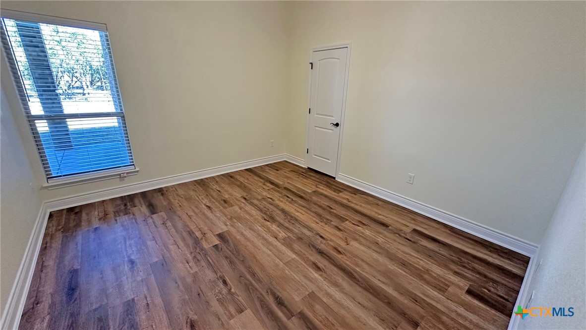 4237 Cool Basin Road Kempner, TX 76539 - Photo 25 of 36 a view of an empty room with wooden floor and a window