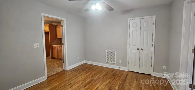 an empty room with wooden floor and a window