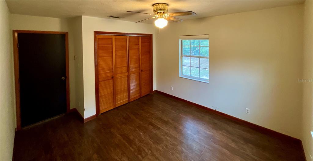 600 Wakulla Street Florahome, FL 32140 - Photo 18 of 47 a view of an empty room with wooden floor and a window