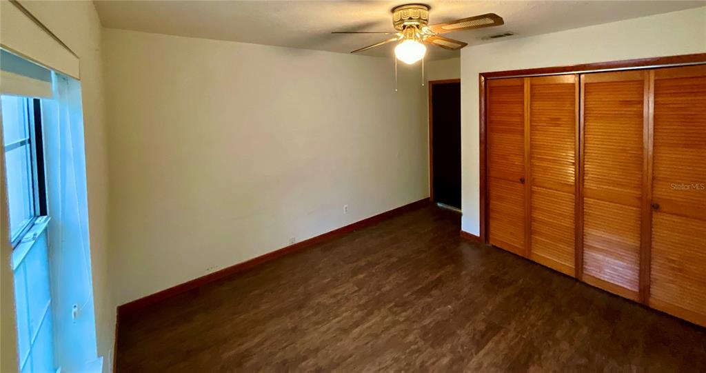 600 Wakulla Street Florahome, FL 32140 - Photo 21 of 47 an empty room with wooden floor fan and windows