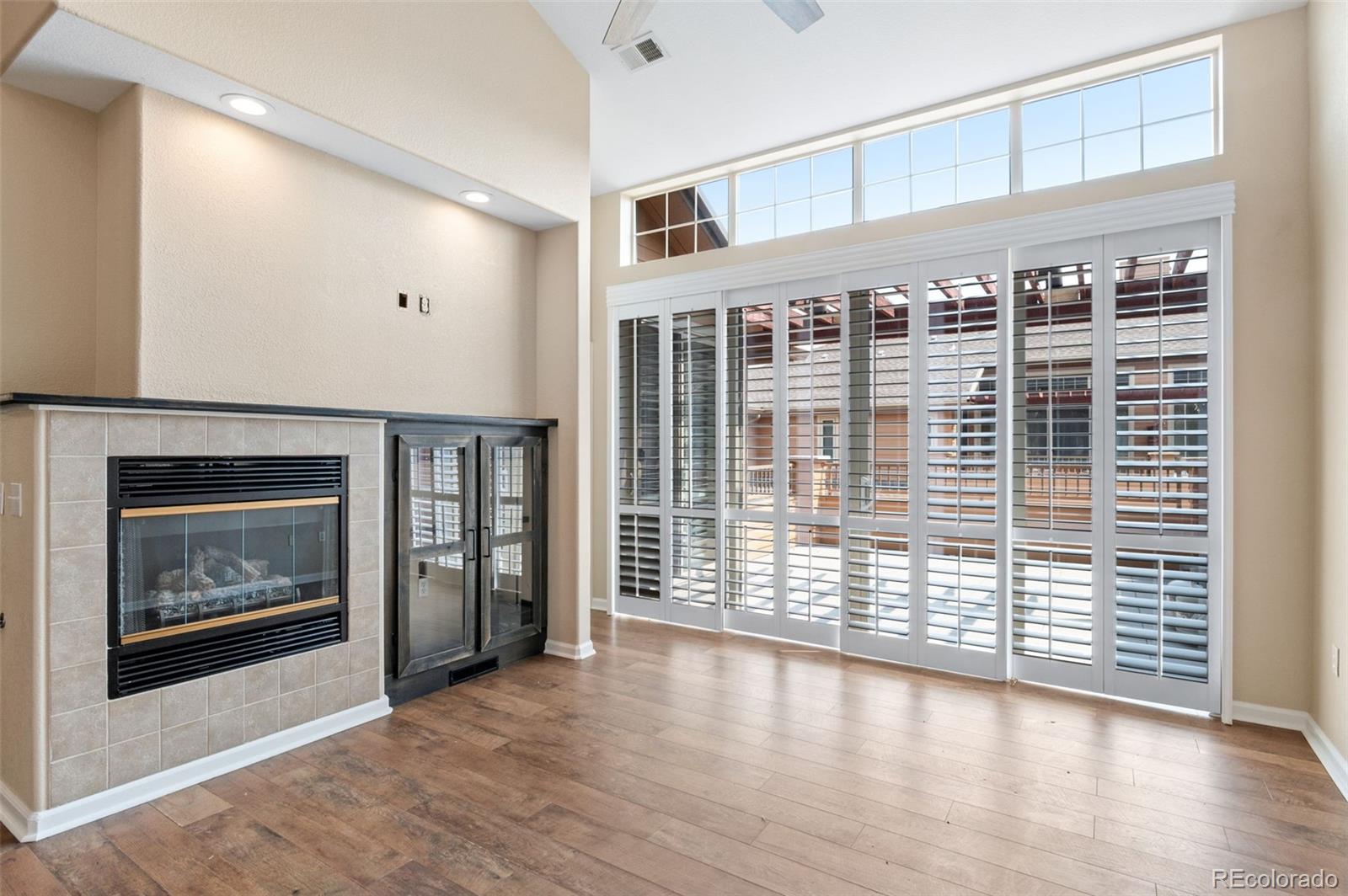 8540 Gold Peak Lane, Unit C Highlands Ranch, CO 80130 - Photo 12 of 37 a view of an empty room with wooden floor and a fireplace