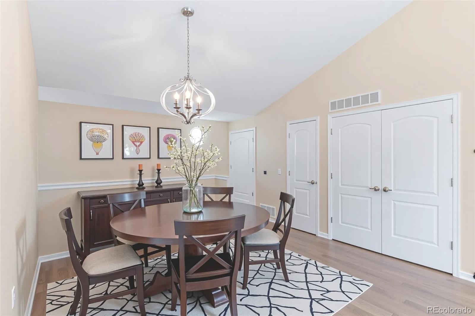 8540 Gold Peak Lane, Unit C Highlands Ranch, CO 80130 - Photo 7 of 37 a dining room with wooden floor a chandelier a wooden table and chairs