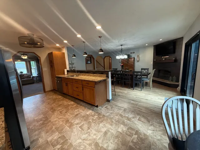 a kitchen with stainless steel appliances kitchen island granite countertop a refrigerator and a sink