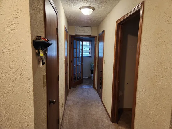 a view of a hallway with wooden shelves