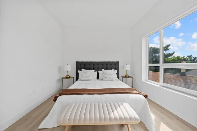 a bed sitting in a bedroom next to a window