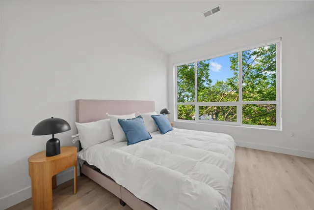 a bedroom with a bed and a large window