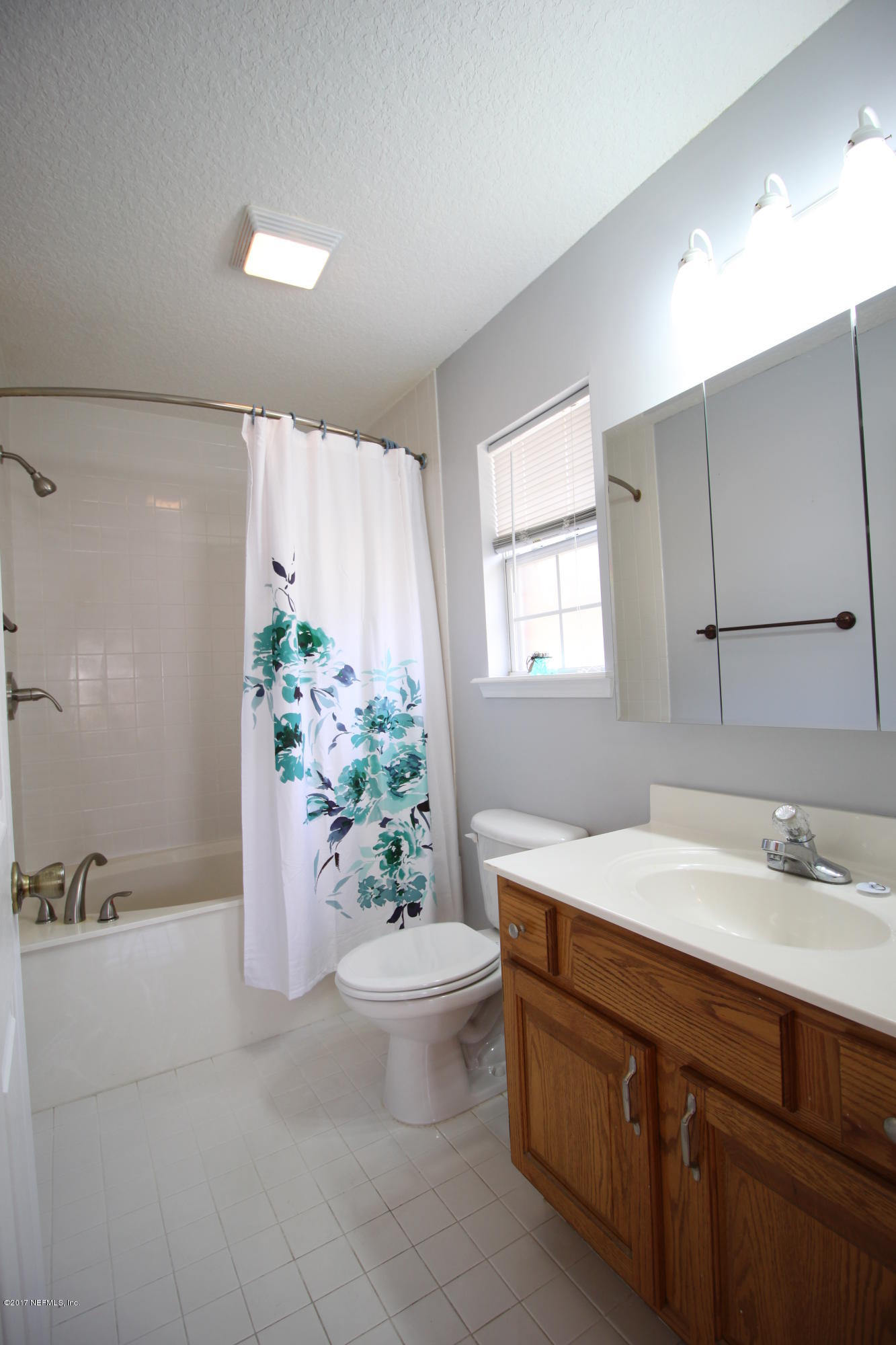 54303 Cravey Road Callahan, FL 32011 - Photo 12 of 13 a bathroom with a granite countertop sink a toilet a mirror and vanity