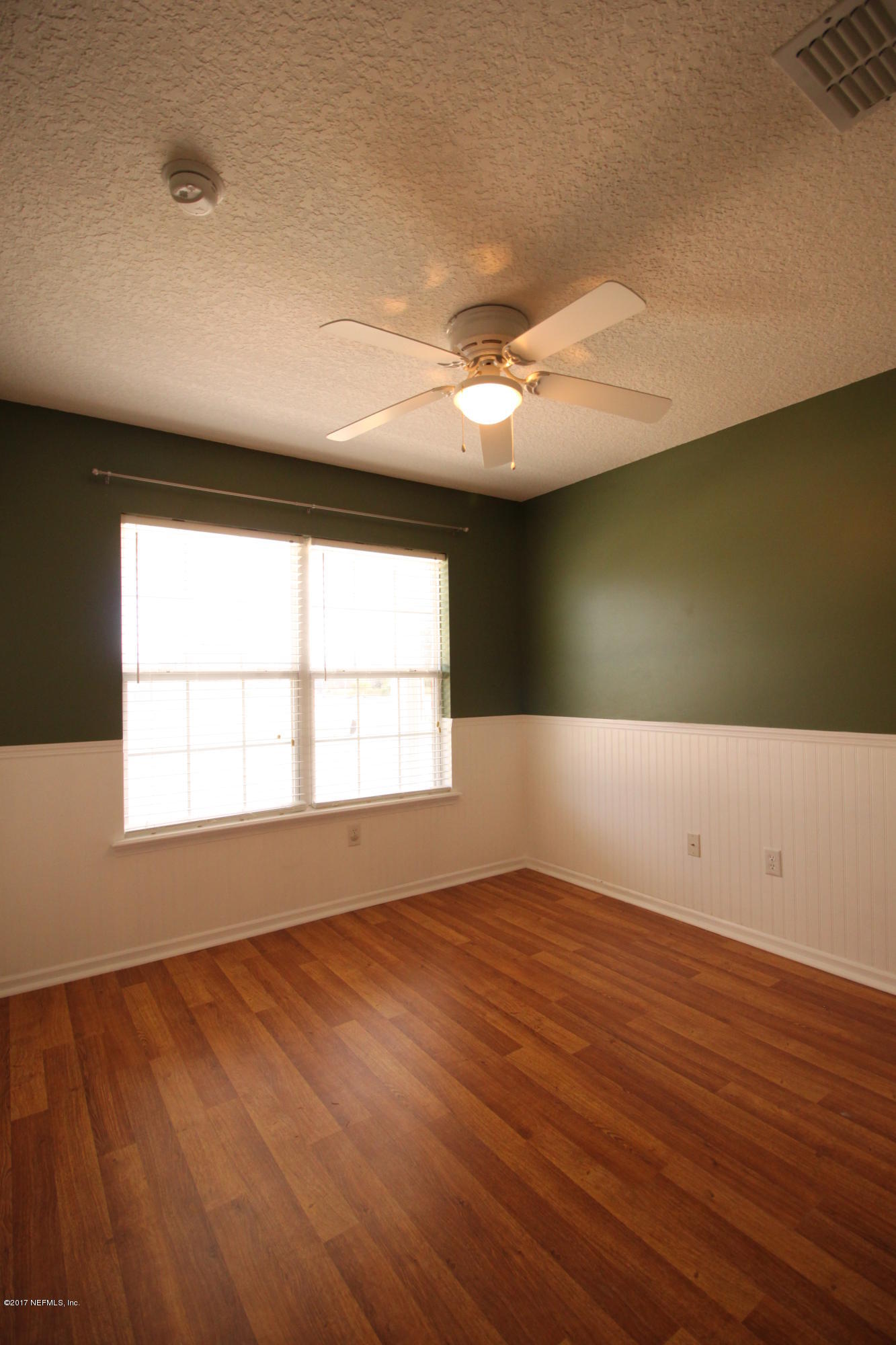 54303 Cravey Road Callahan, FL 32011 - Photo 7 of 13 an empty room with wooden floor and windows