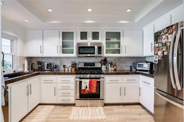 a kitchen with stainless steel appliances granite countertop a stove top oven a sink and dishwasher