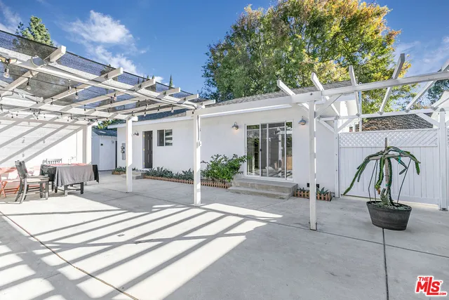 a view of a patio with a table and chairs and potted plants