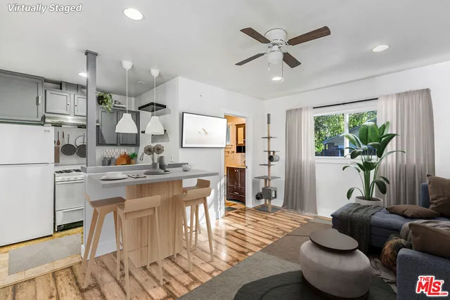 a living room with kitchen island furniture and a view of kitchen