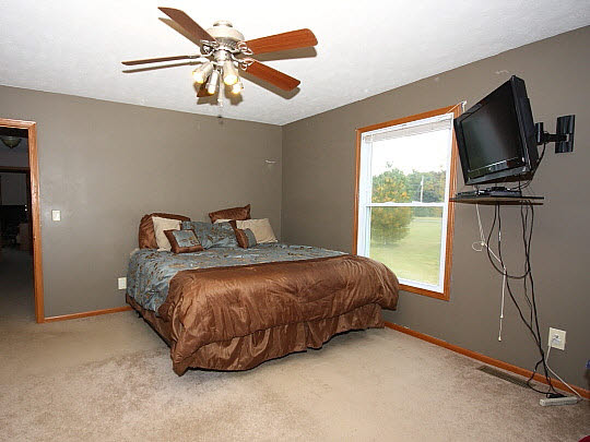 11601 East Kyte Road Rochelle, IL 61068 - Photo 5 of 11 a bedroom with a bed and a flat tv screen on the wall