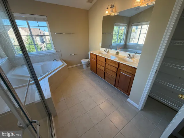 a view of an empty room with wooden floor and windows