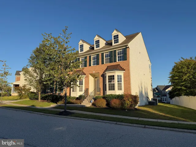 a front view of a house with a yard and potted plants