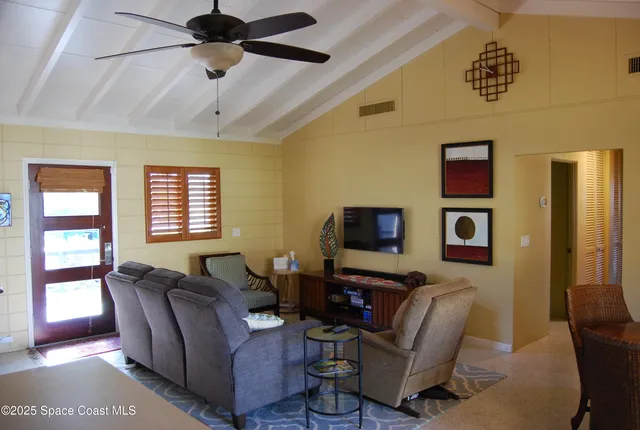 a living room with furniture a ceiling fan and a window