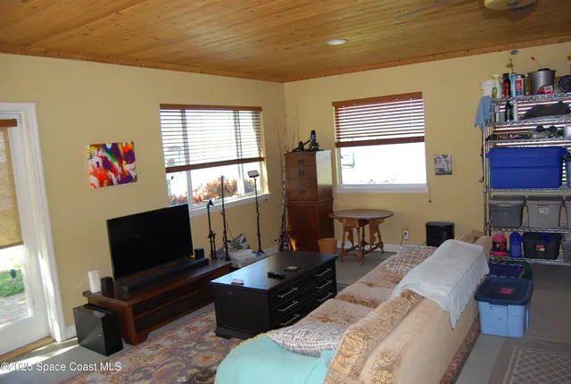 a living room with furniture a flat screen tv and a window