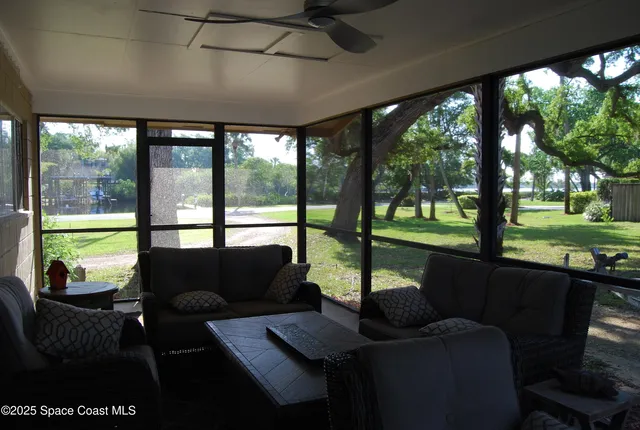 a living room with furniture and a floor to ceiling window