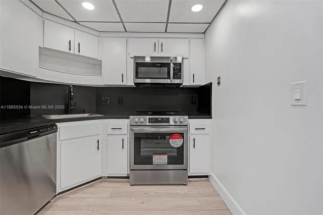 a kitchen with stainless steel appliances granite countertop a stove and a microwave