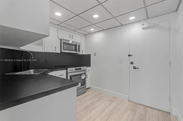 a view of a kitchen with refrigerator and cabinet