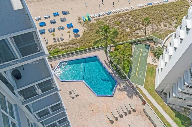a view of a swimming pool with a lounge chair and palm trees