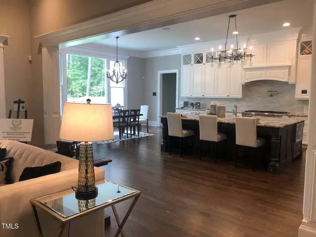 a large kitchen with a table chairs wooden floor and a window