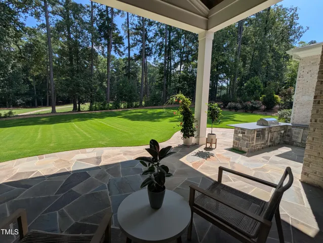 a view of a patio with a table chairs and a backyard