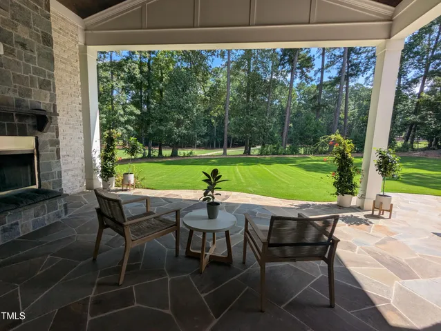 a table and chairs with the view of garden in balcony
