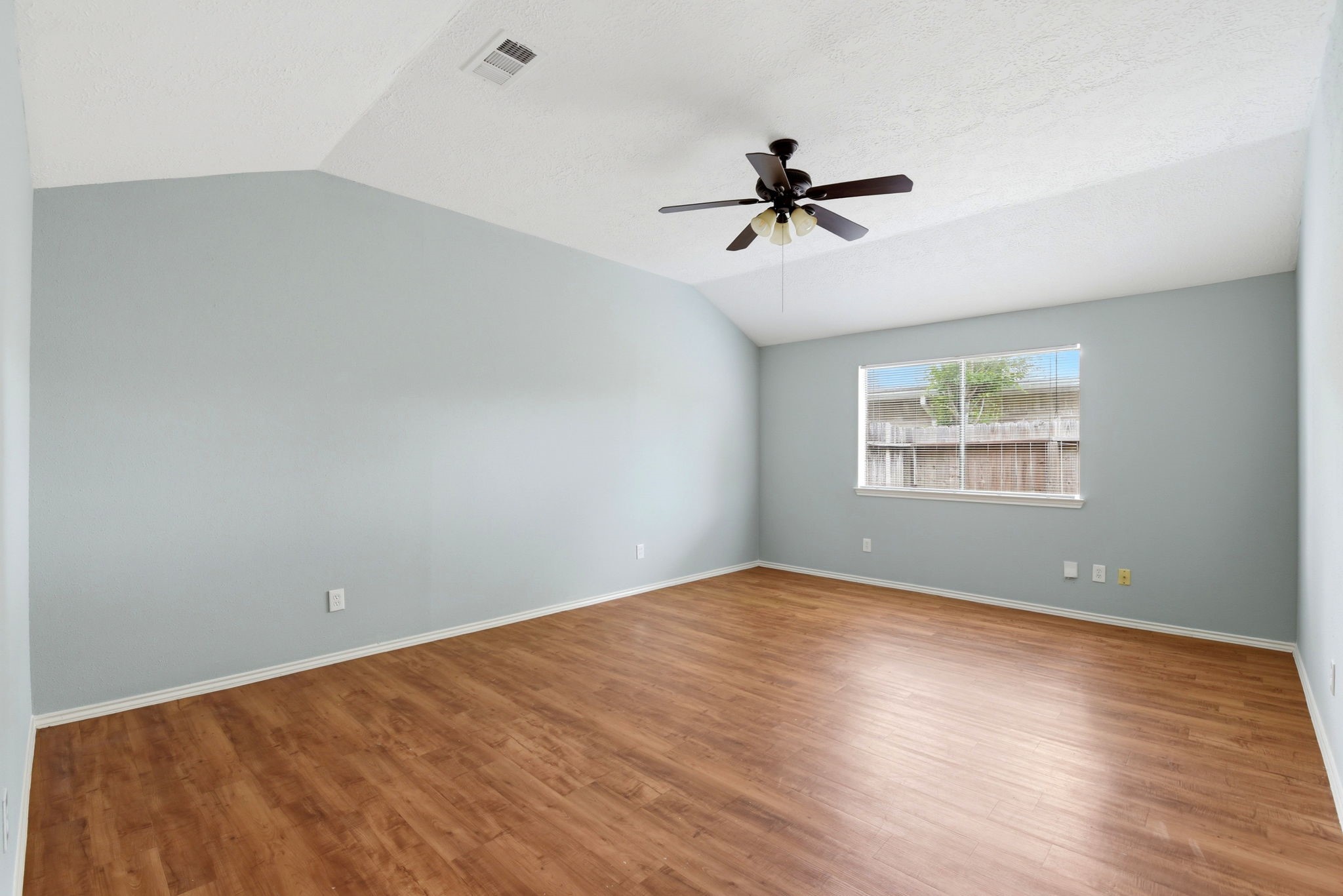 21330 Golden Dove Drive Spring, TX 77388 - Photo 13 of 29 Retreat to your private primary suite! You will love the soaring vaulted ceiling and the continuation of the beautiful laminate flooring.