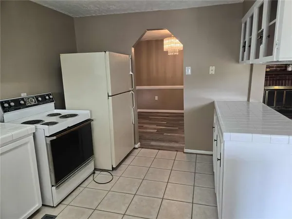 a kitchen with a refrigerator sink and cabinets