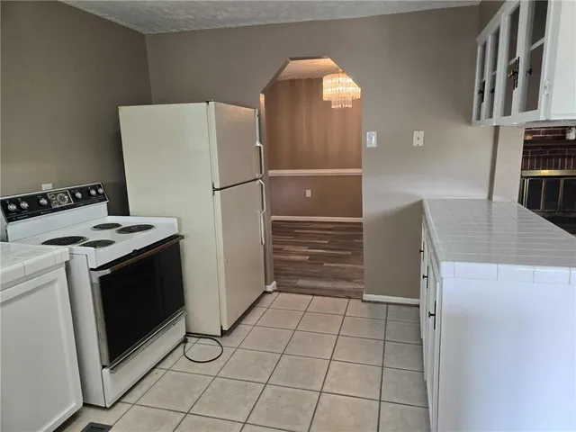 a kitchen with a refrigerator sink and cabinets