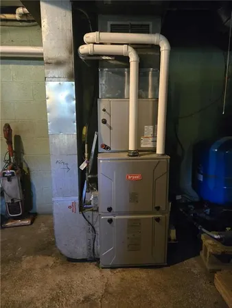 a room with water heater and wooden cabinets