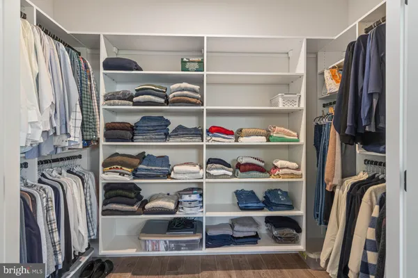 a view of walk in closet with clothes and shoes
