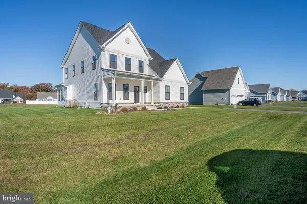 a white house with a big yard and more windows