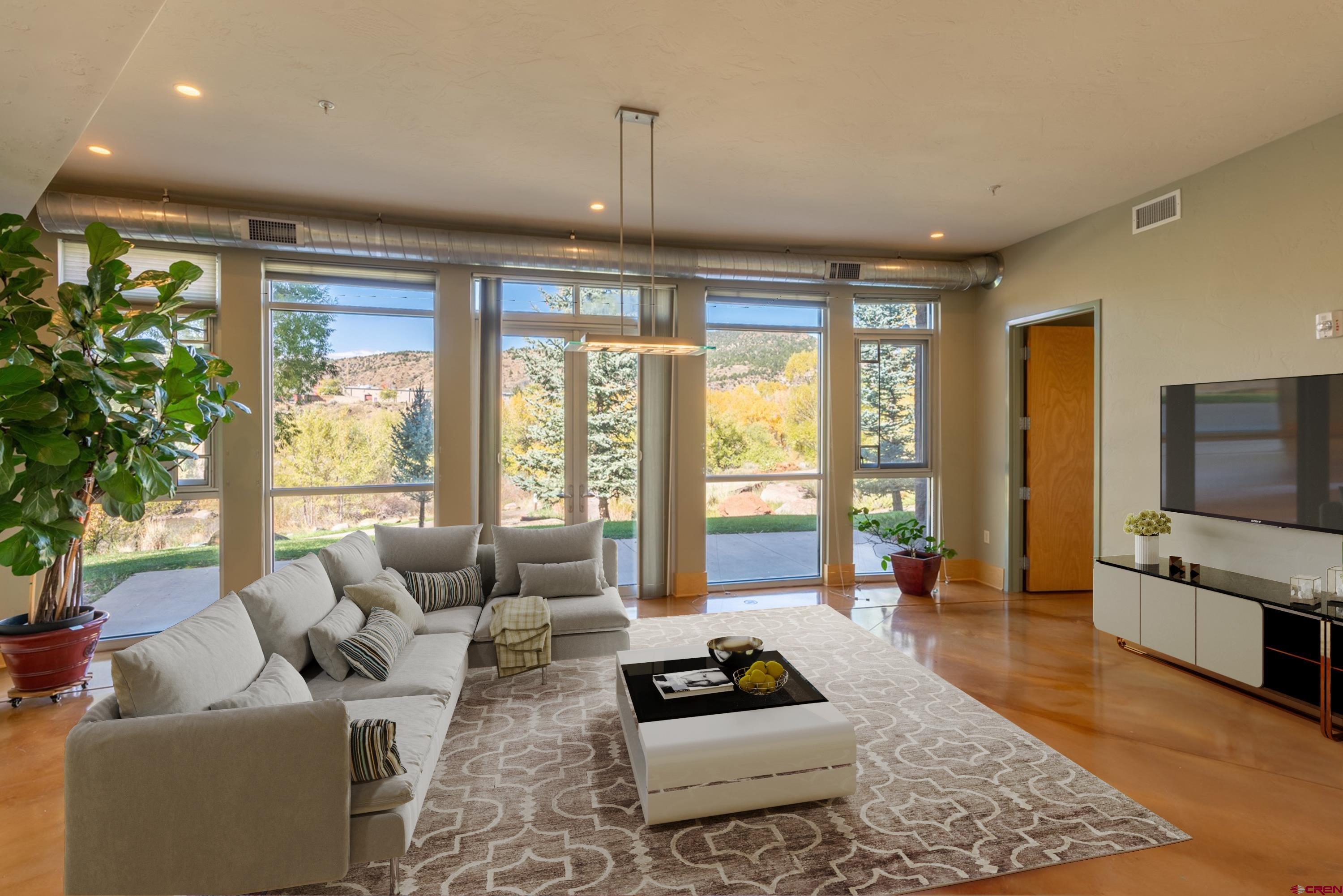 555 Rivergate Lane, Unit B482 Durango, CO 81301 - Photo 13 of 35 a living room with furniture a flat screen tv and a large window