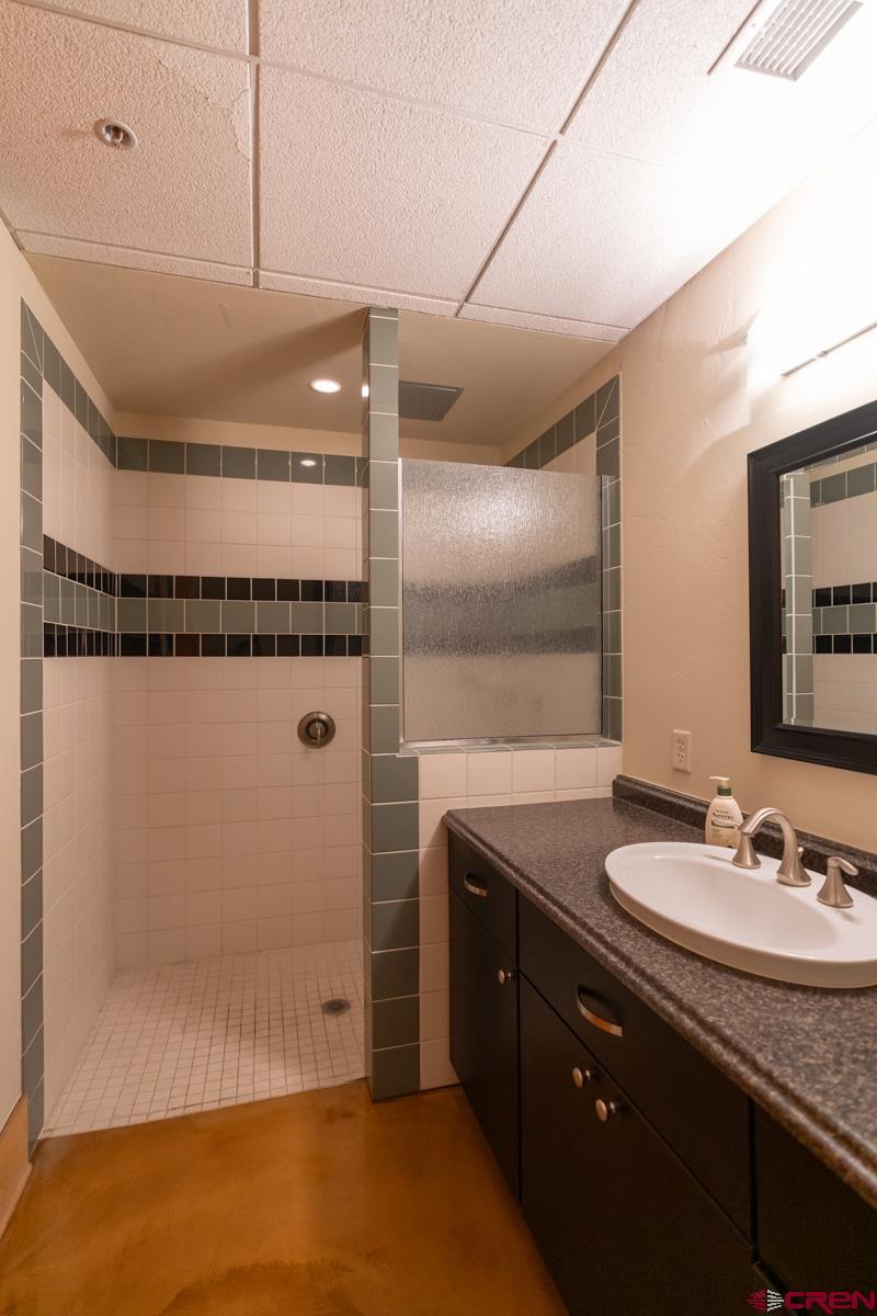 555 Rivergate Lane, Unit B482 Durango, CO 81301 - Photo 30 of 35 a bathroom with a granite countertop sink a mirror and shower