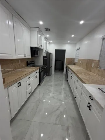 a large kitchen with stainless steel appliances lots of counter top space