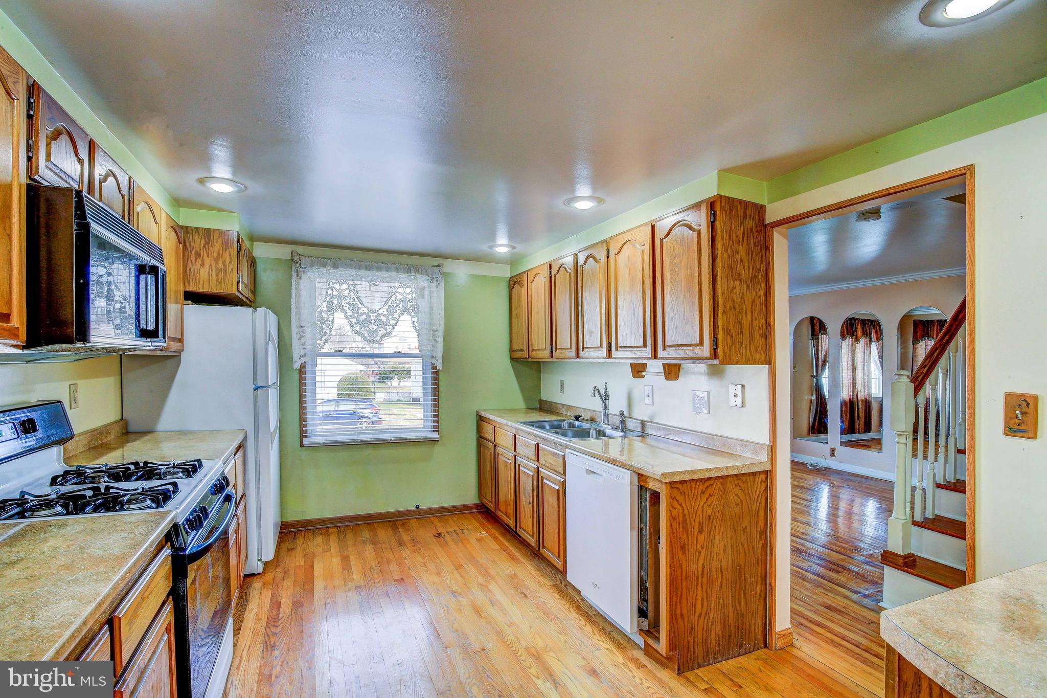 a kitchen with stainless steel appliances granite countertop a stove and a wooden floors