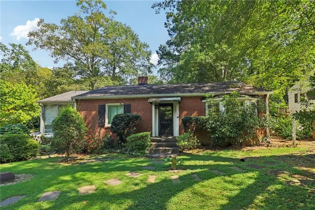 a view of a house with a yard and potted plants