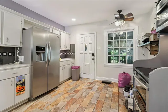 a kitchen with stainless steel appliances granite countertop a refrigerator a oven a sink with island and windows