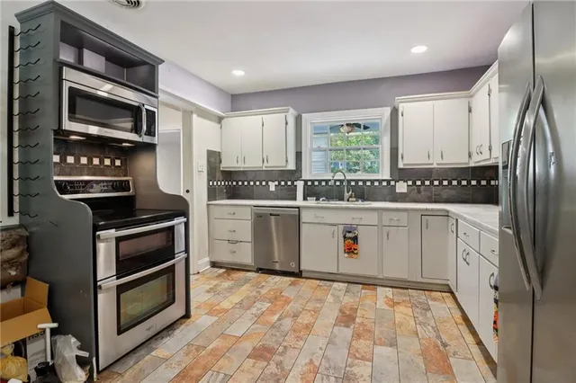 a kitchen with stainless steel appliances a stove sink and cabinets
