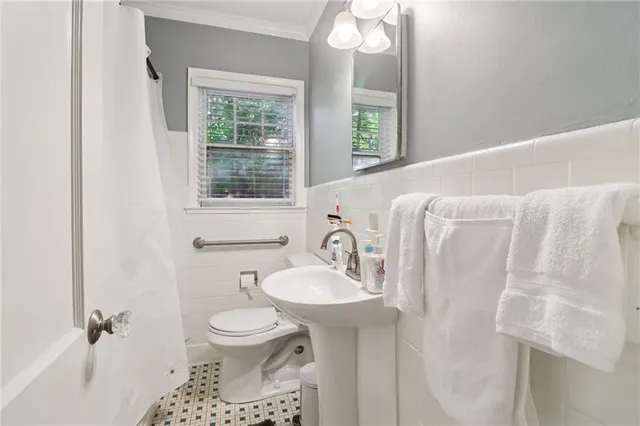 a bathroom with a sink toilet and a mirror