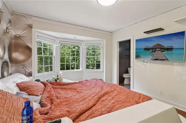 a bedroom with a bed and a large window